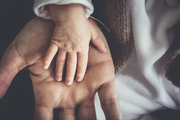 la main d'un bébé dans celle d'une maman