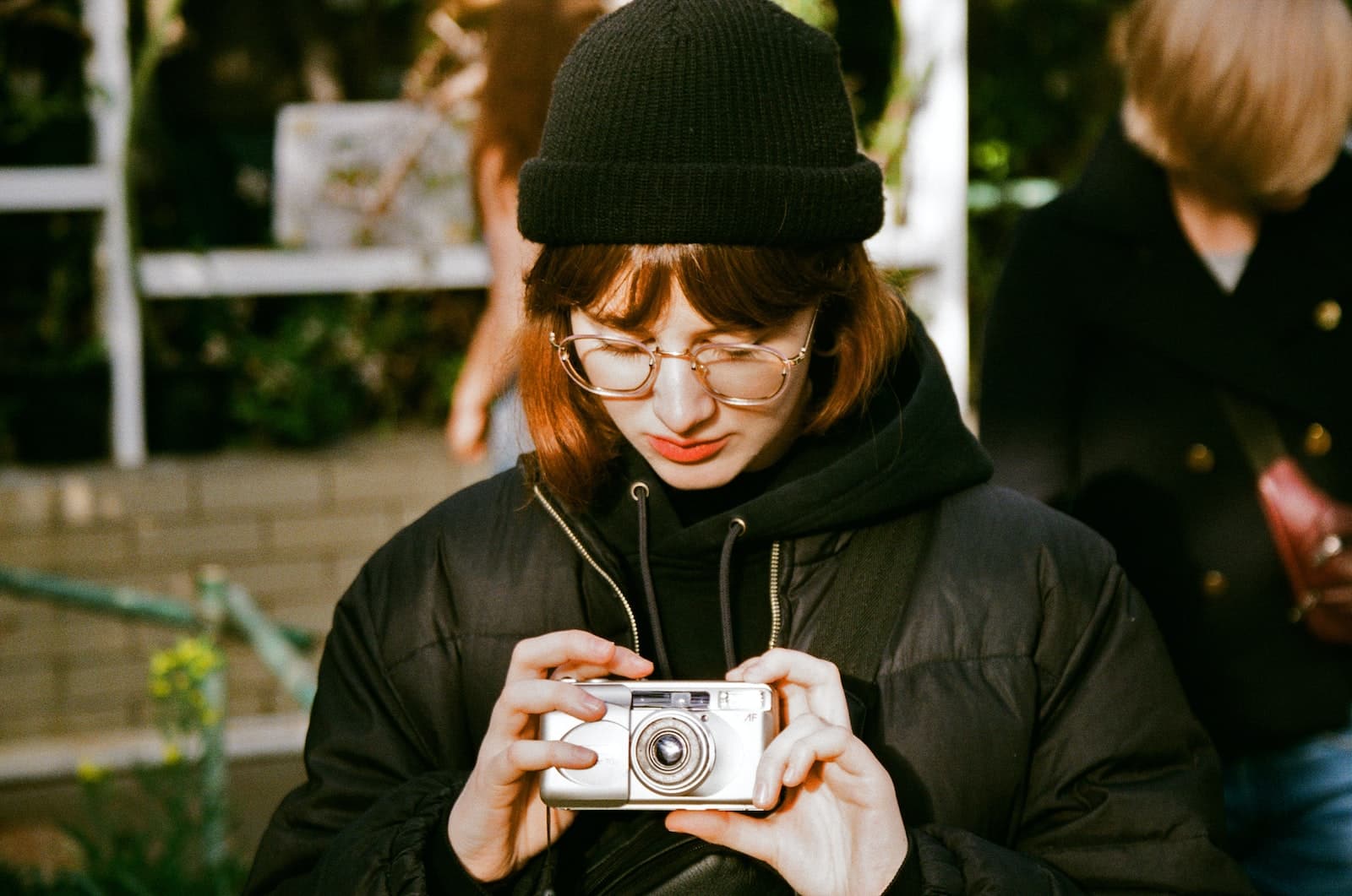 woman in black knit cap holding camera