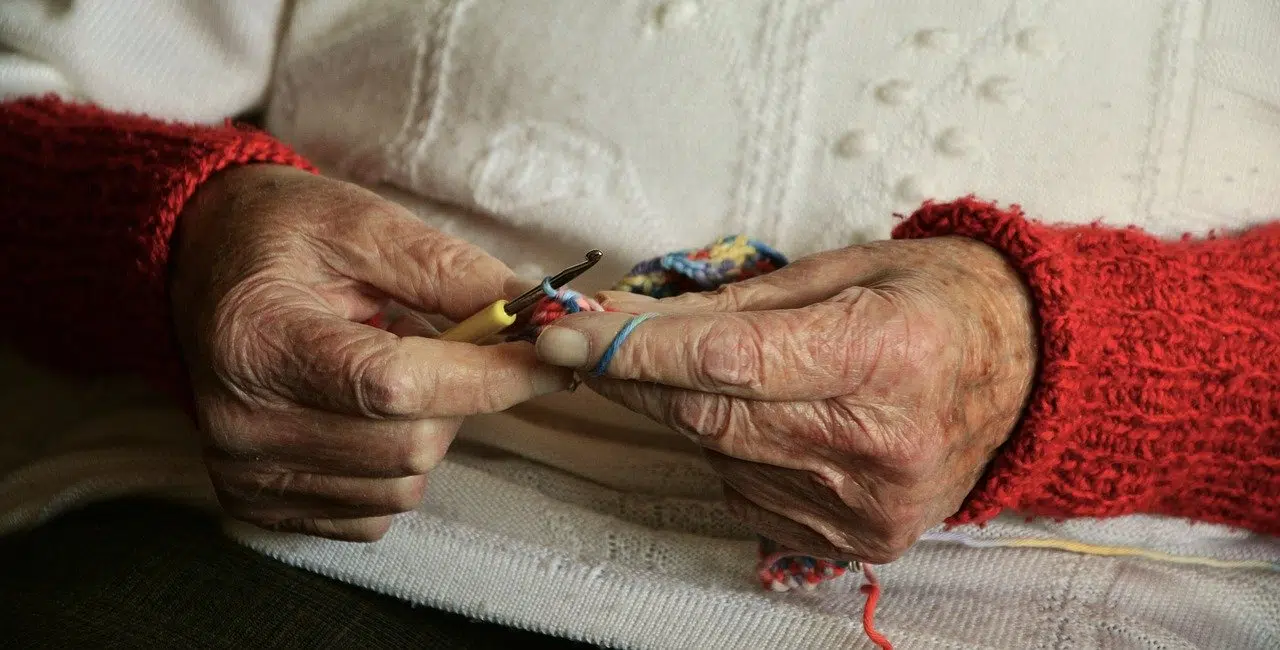 Les mains d'une personne âgée qui tricote